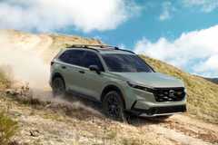 Dynamic front 3/4 shot of a green 2026 Honda CR-V TrailSport off-roading.
