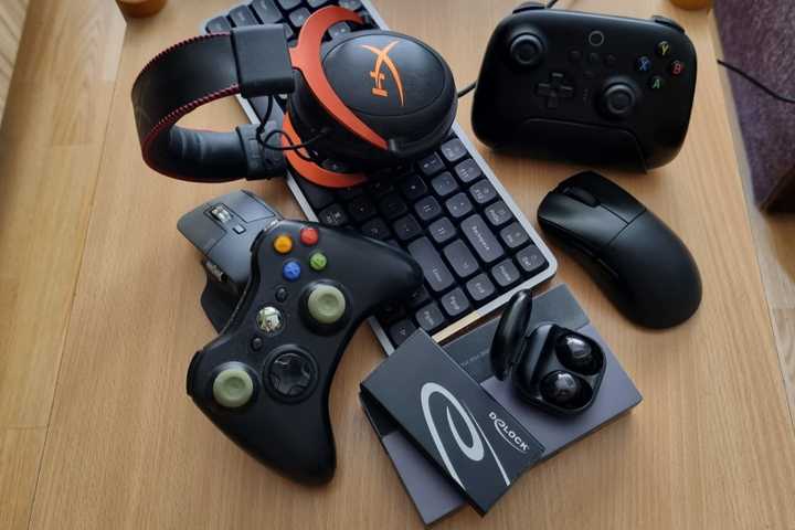 A bunch of gadgets lying on a table. 