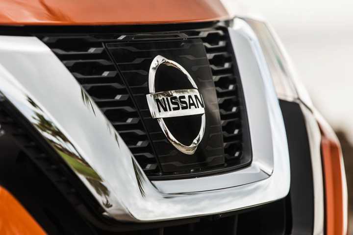 2017.5_Nissan_Rogue_SL_14-sourceClose-up shot of the grille on a orange 2017 Nissan Rogue.