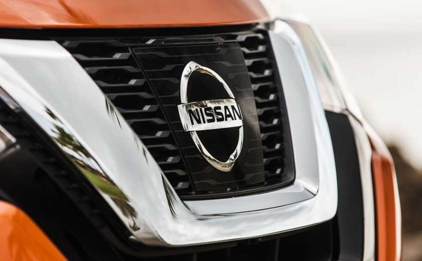 2017.5_Nissan_Rogue_SL_14-sourceClose-up shot of the grille on a orange 2017 Nissan Rogue.