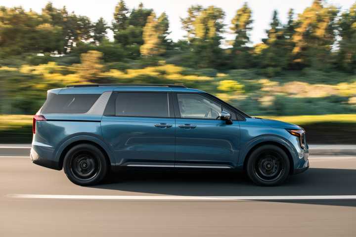 Side profile action shot of a 2025 Kia Carnival 