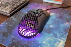 A closeup of the steelseries aerox 5 wired gaming mouse on a galaxy mouse pad.