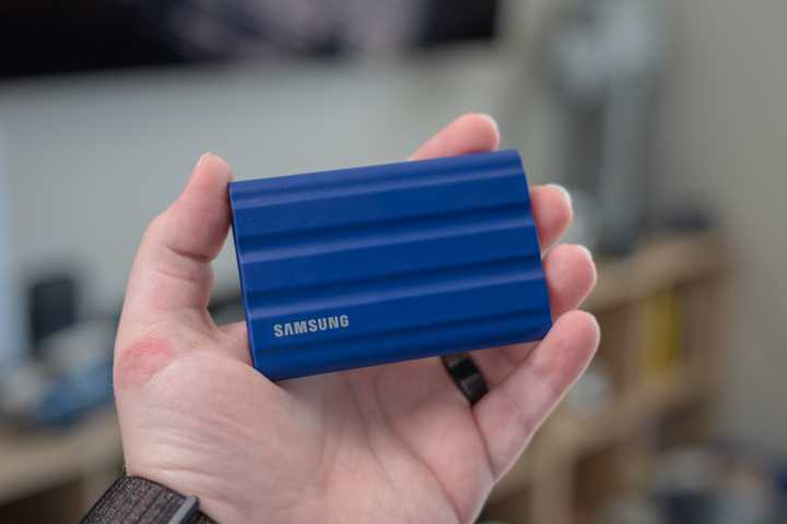 Samsung T7 Shield portable SSD held in a person's hand.