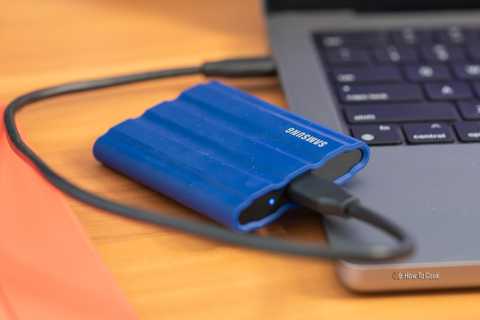 Samsung T7 Shield SSD sitting next to an Apple MacBook computer.
