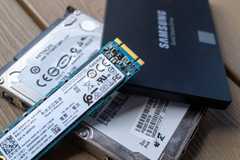 ASamsung 850 EVO SSD with a M.2 SSD and SATA hard drive on a table.