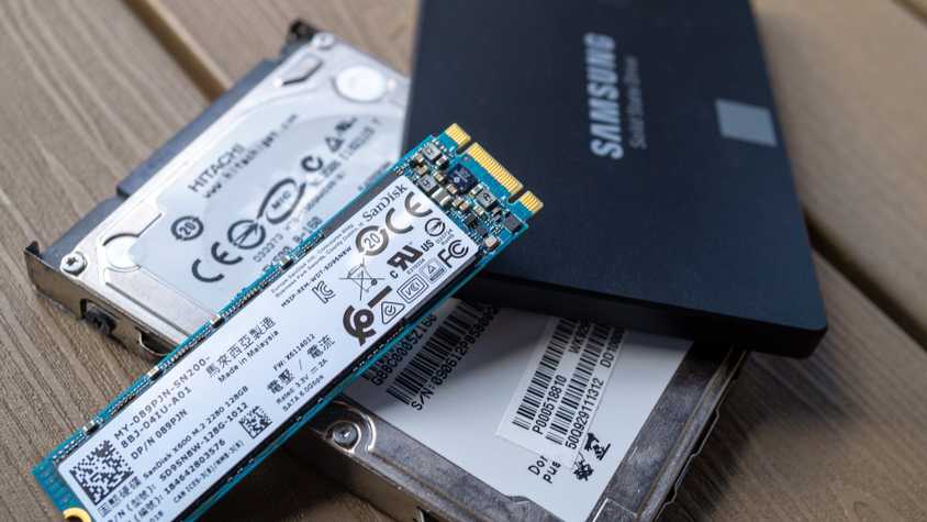 ASamsung 850 EVO SSD with a M.2 SSD and SATA hard drive on a table.