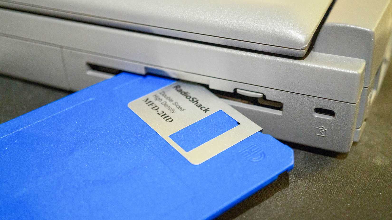 Floppy disk and drive on laptop.