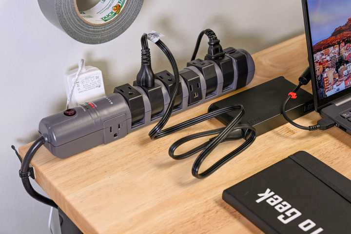 A Belkin surge protector on a workbench with cables plugged into it