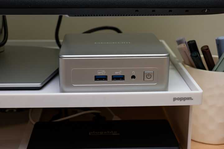 A GEEKOM AE7 mini PC sitting on a desk.