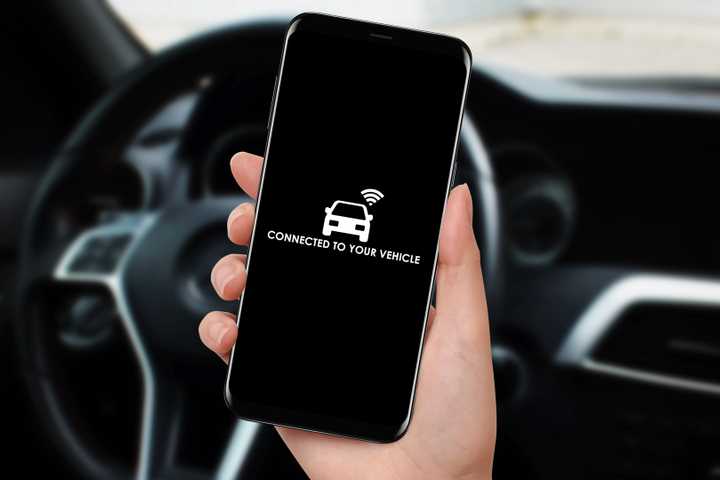 Woman connecting car with her smartphone and app using WiFi.