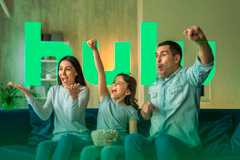 A family watching TV with the Hulu logo in the background.