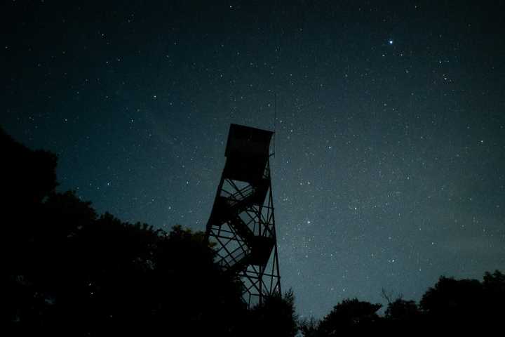 A firewatch tower with the night sky in the background.