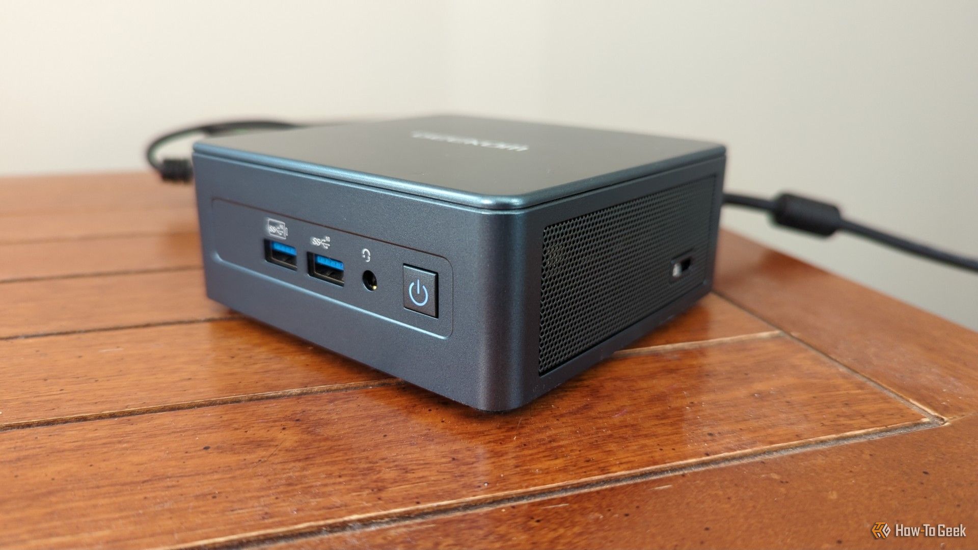 A Geekom mini PC plugged in and powered on.-1