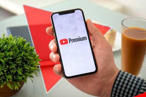 a hand holding a phone with youtube premium logo on the screen.