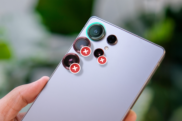 A hand holding a smartphone with three cameras crossed out.