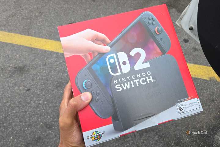 A hand holding the box of a Nintendo Switch 2.