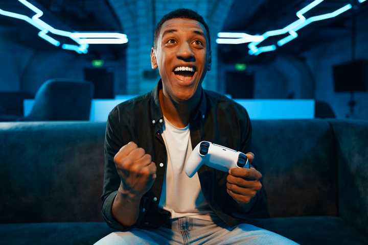 A happy man holding a video game controller.