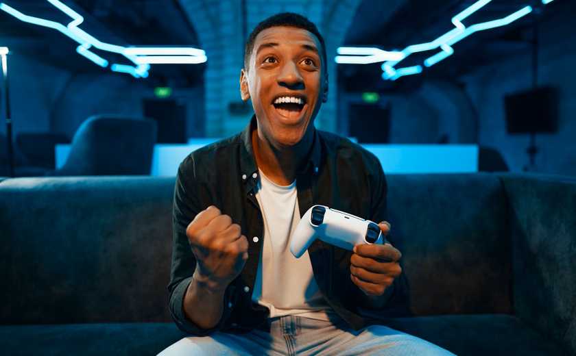 A happy man holding a video game controller.