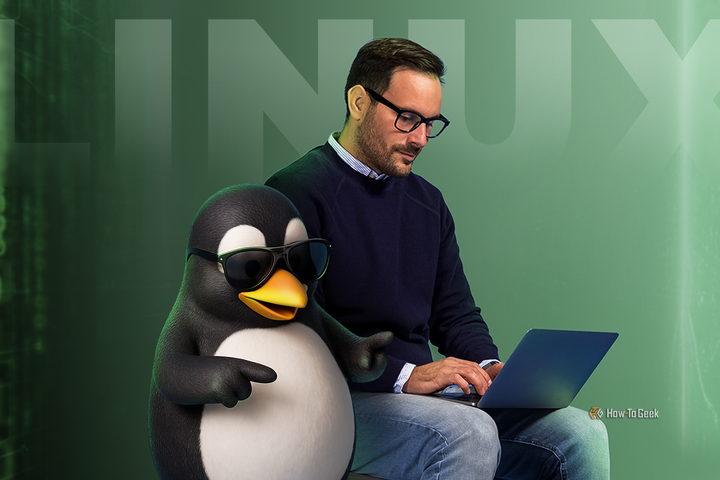 A man using a laptop next to Tux, the Linux mascot wearing sunglasses.