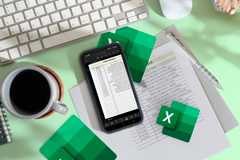 A phone with an Excel spreadsheet and a paper with the same spreadsheet printed.