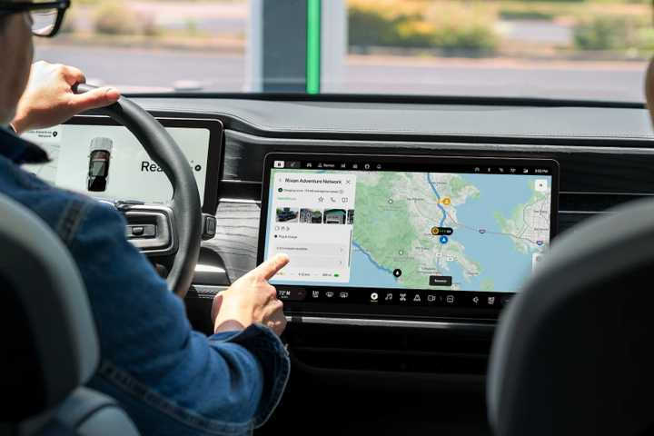 A Rivian EV driver using his dashboard to navigate with Google Maps.