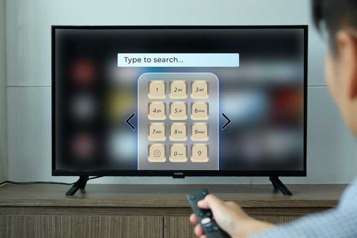 A smart TV with a T9 keyboard layout on the screen in a retro style.