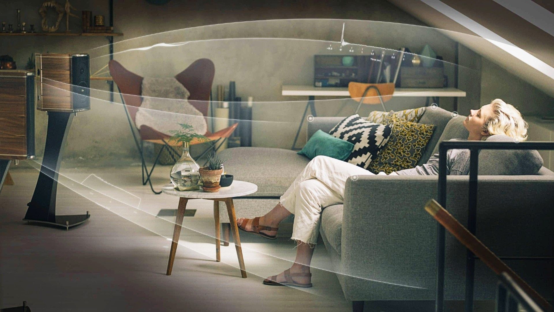 A woman sitting on her couch after Dirac Live adjusted her speaker settings.