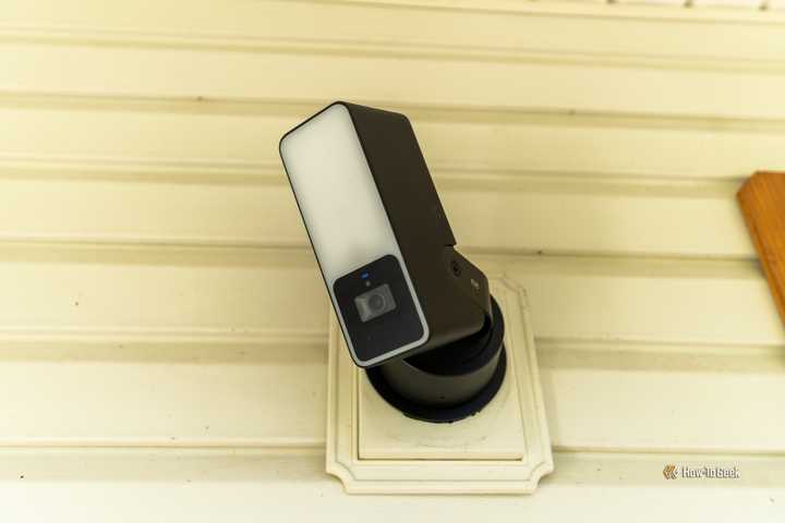 The front of the Eve Outdoor Cam mounted to a wall.