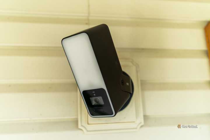 The Eve Outdoor Cam head-on mounted to a wall on a front porch.