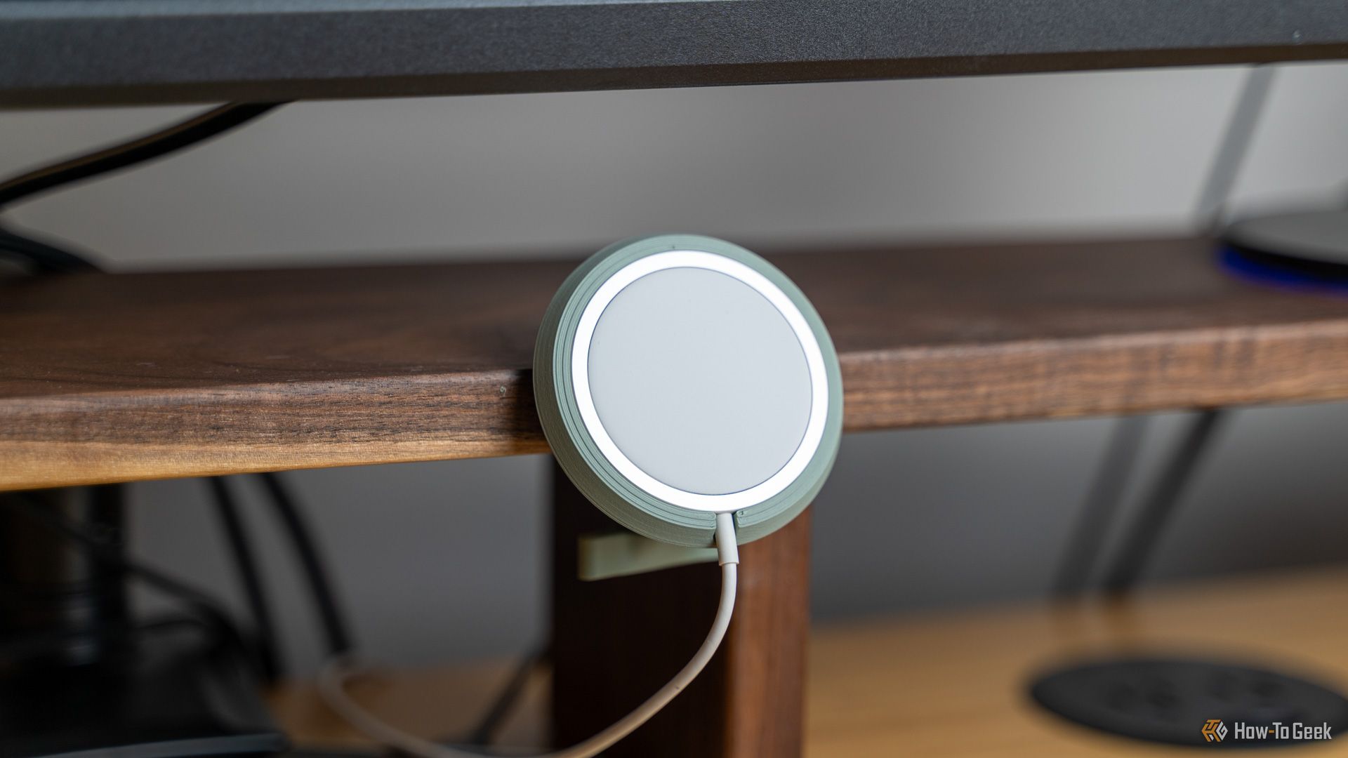 A 3D printed MagSafe charger holder mounted to a Walnut desk shelf.