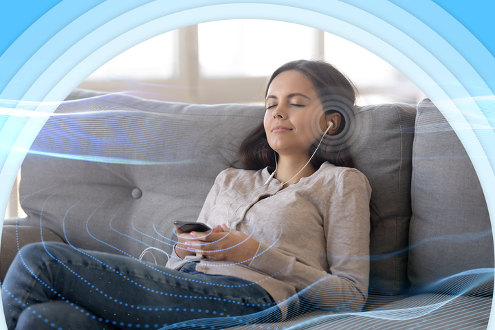 A woman relaxing on a couch with her eyes closed, using earphones connected to her smartphone, surrounded by soft blue sound waves and curved visual effects.