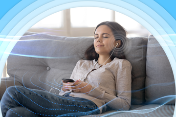 A woman relaxing on a couch with her eyes closed, using earphones connected to her smartphone, surrounded by soft blue sound waves and curved visual effects.