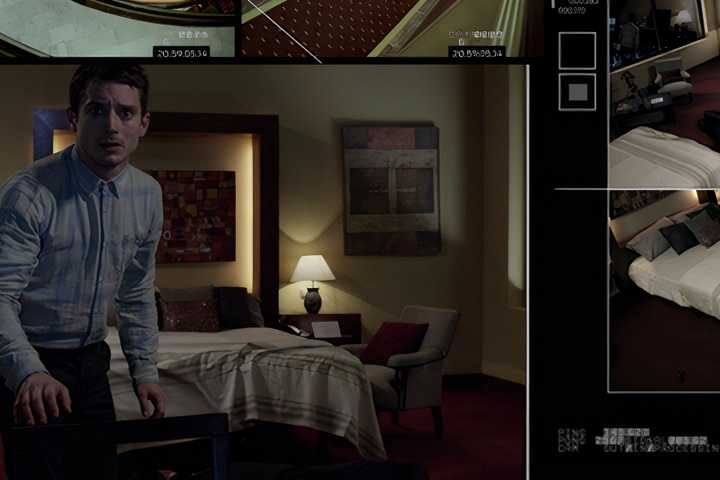 Elijah Wood in a bedroom shown through a computer screen in the movie Open Windows