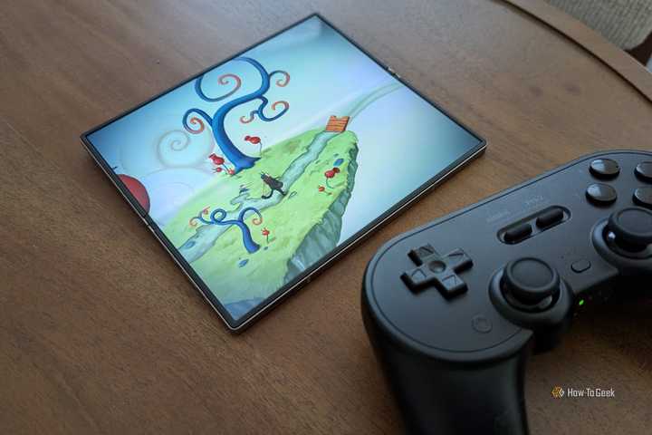 'Figment' in a Galaxy Z Fold 6 next to an 8BitDo Pro 2 controller.