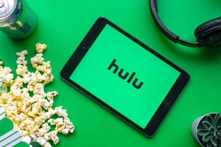 Hulu logo on a screen surrounded by popcorn and headphones.