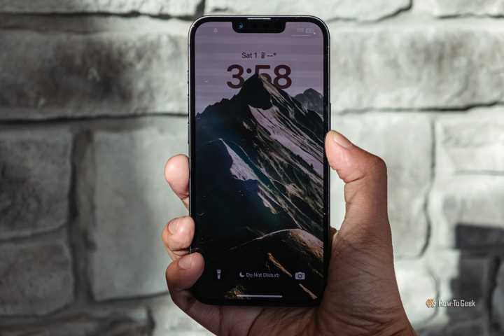 iPhone 16e in hand with lockscree.