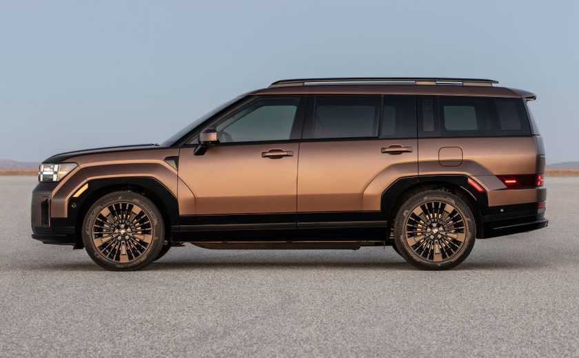 Static side profile shot of a bronze 2025 Hyundai Santa Fe Hybrid parked on a salt plain.