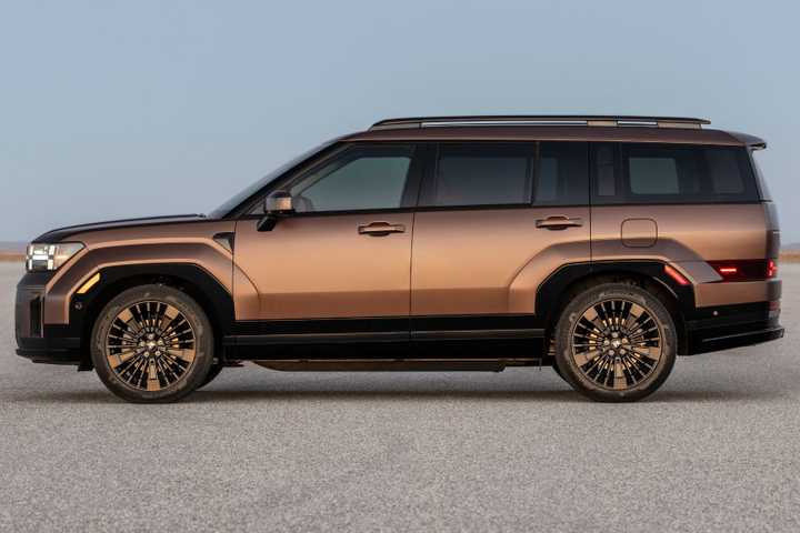 Static side profile shot of a bronze 2025 Hyundai Santa Fe Hybrid parked on a salt plain.