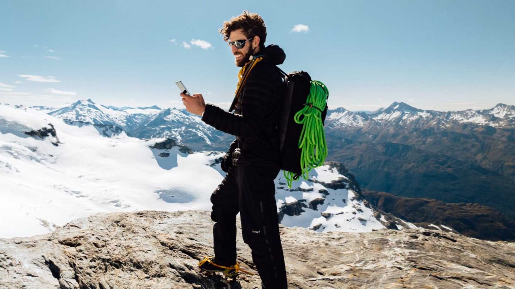 One NZ Satellite Service Starlink man on mountain using phone.