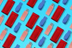 Pattern of USB flash drives and SSDs in different colors arranged on a blue background. Lucas Gouveia/How-To GeekPattern of USB flash drives and SSDs in different colors arranged on a blue background.