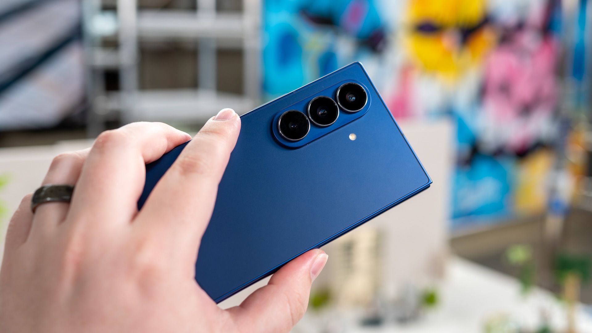 person holding the samsung galaxy z fold 7 unfolded showing the back of the phone and cameras 54642361020 o