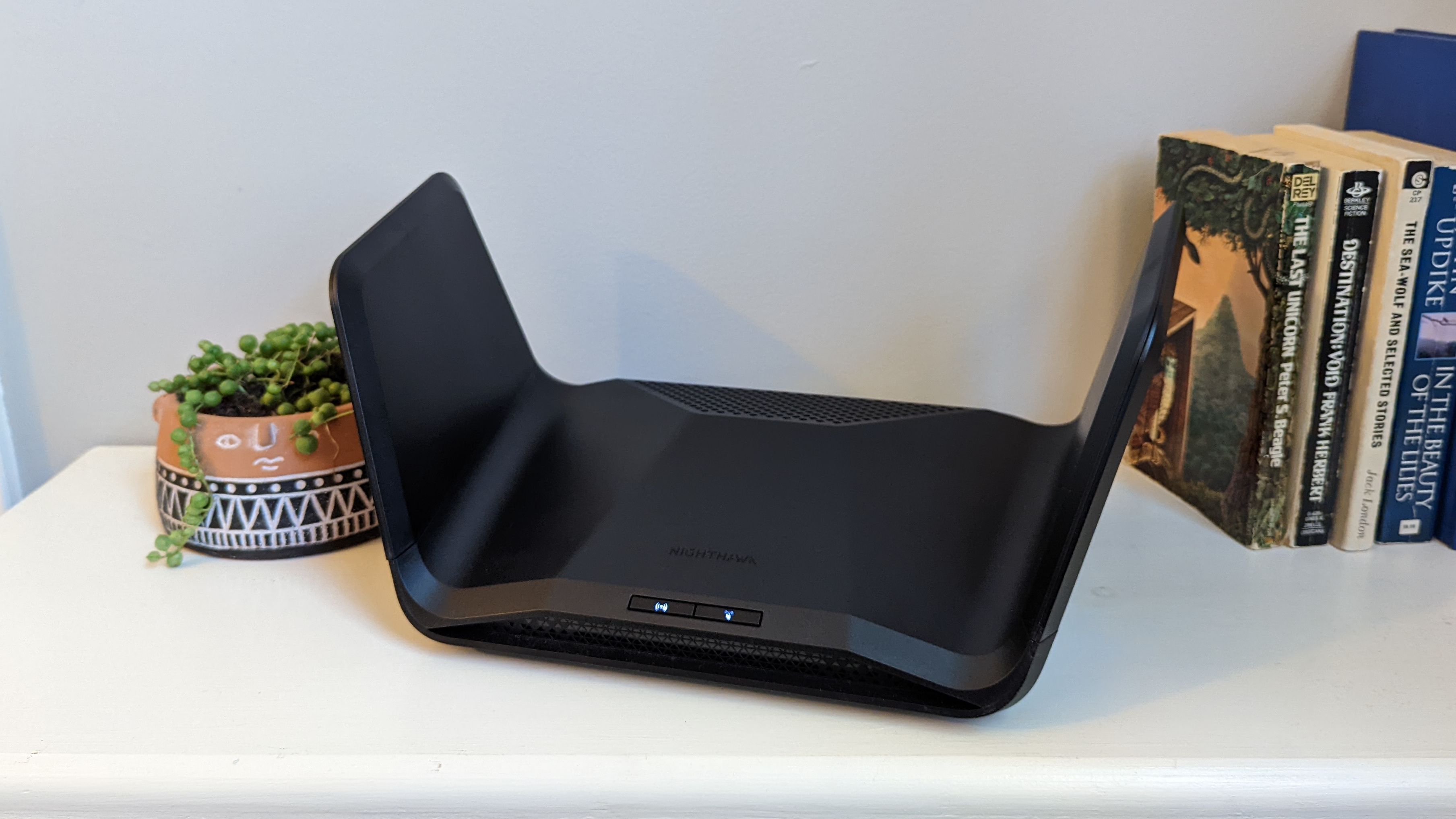The Netgear Nighthawk RAX300 router on a bookshelf.