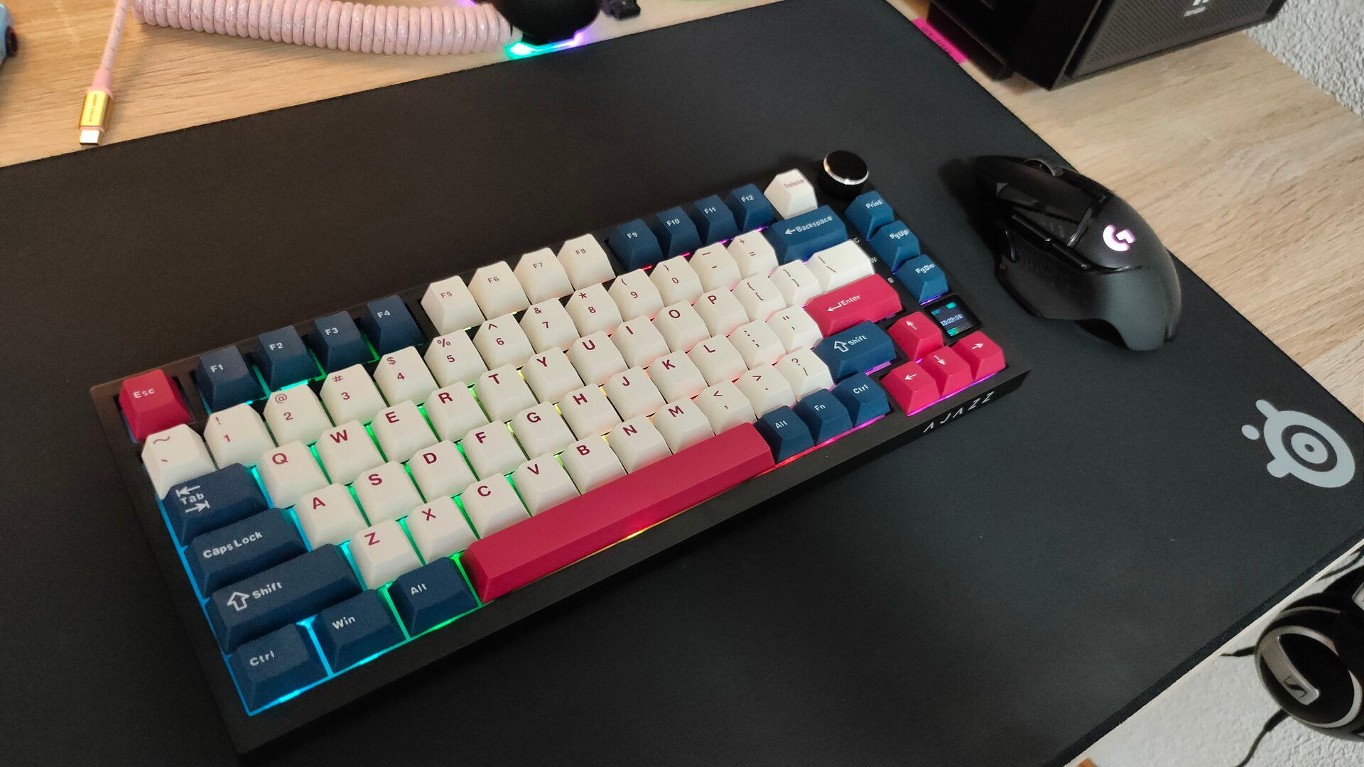 The Ajazz AK820 Pro mechanical keyboard on a black SteelSeries mousepad next to a Logitech mouse.