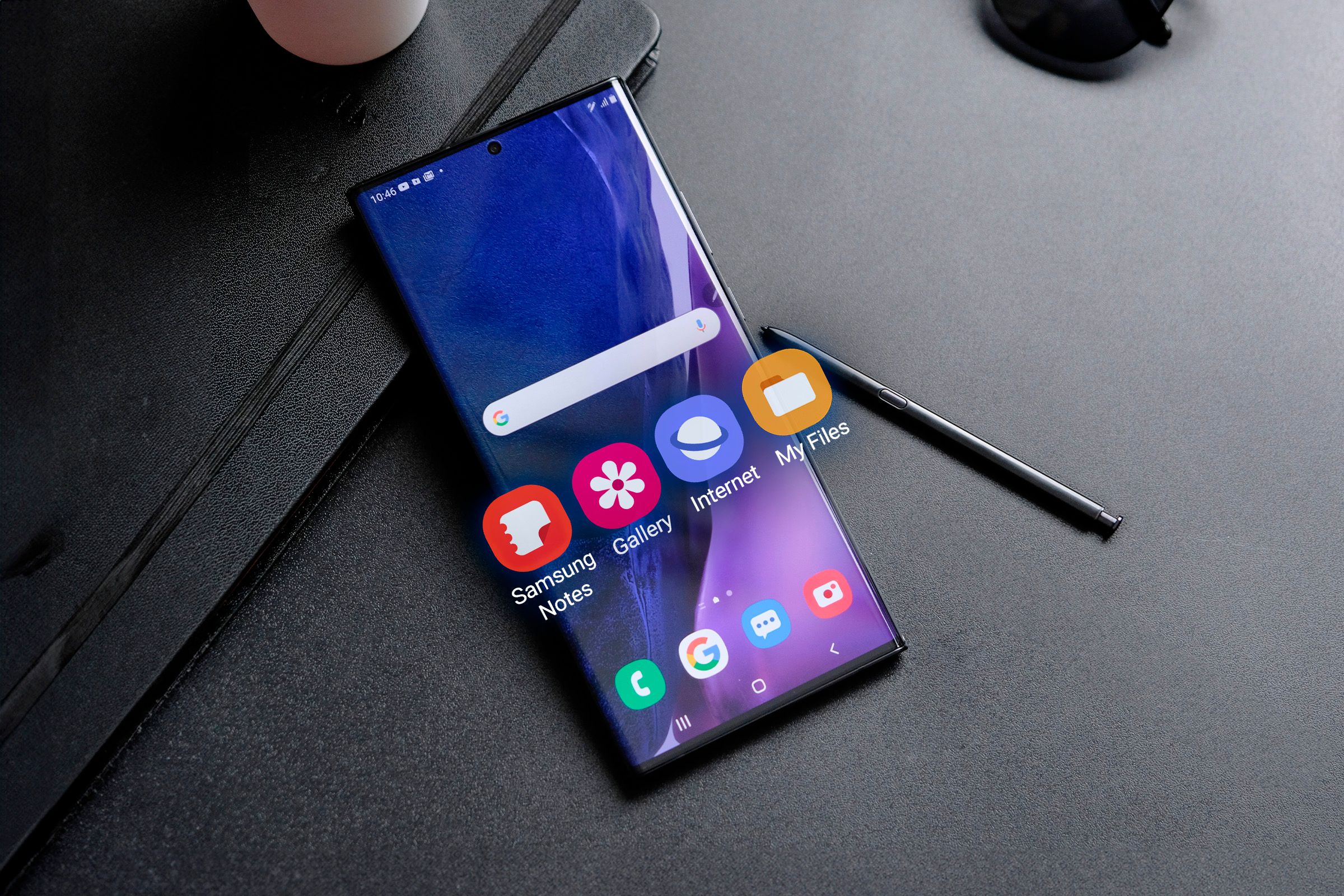 Samsung smartphone with some Stock Apps sticking out of the screen and the S Pen next to it