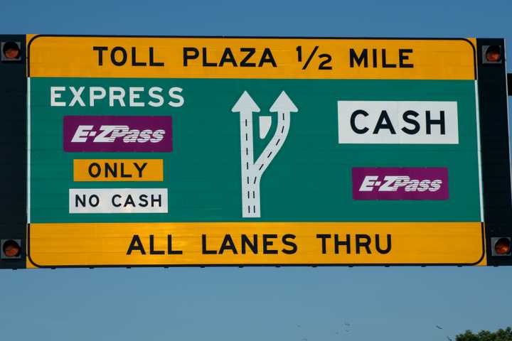A toll sign with E-ZPass notices displayed on the left and right sides. 