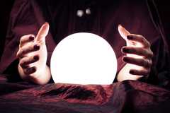 A glowing crystal ball between a fortune teller's hands.