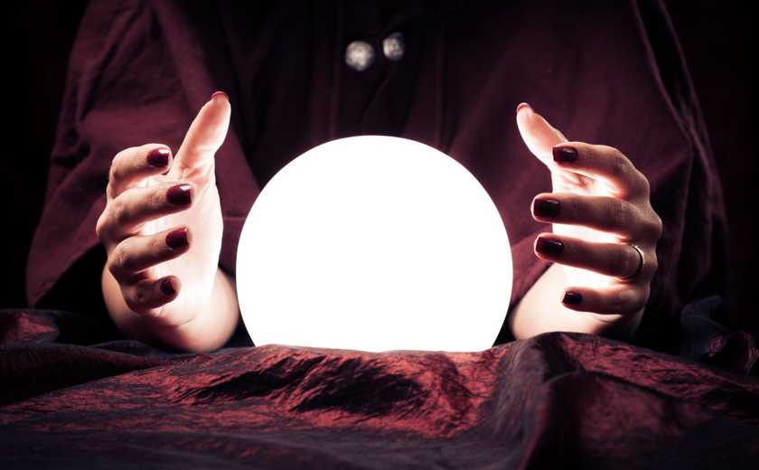 A glowing crystal ball between a fortune teller's hands.