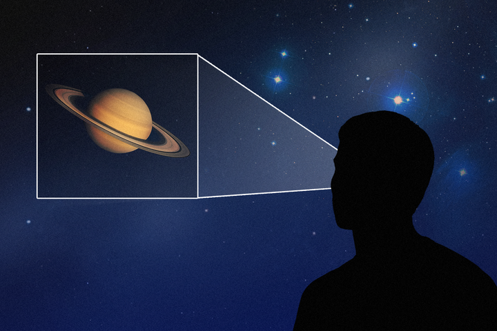 Silhouette of a man observing Saturn in a starry sky.