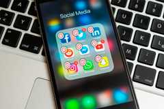 A phone with some social media applications with a clock icon.