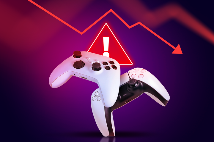 Two video game controllers appear in front of a red warning symbol and a downward graph.